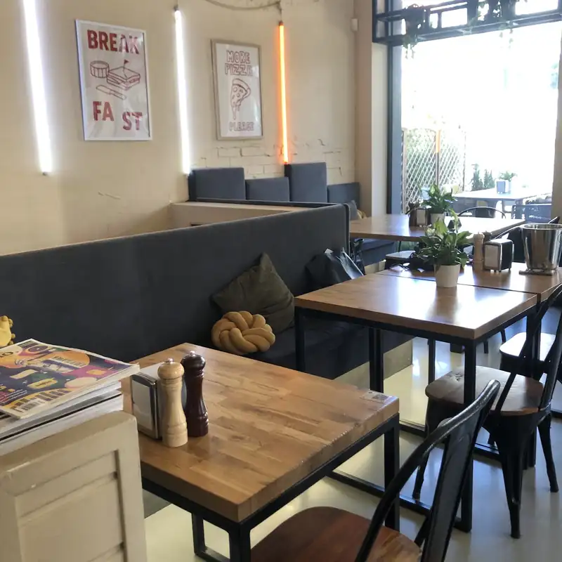 Sala z drewnianymi stolikami i dużym oknem